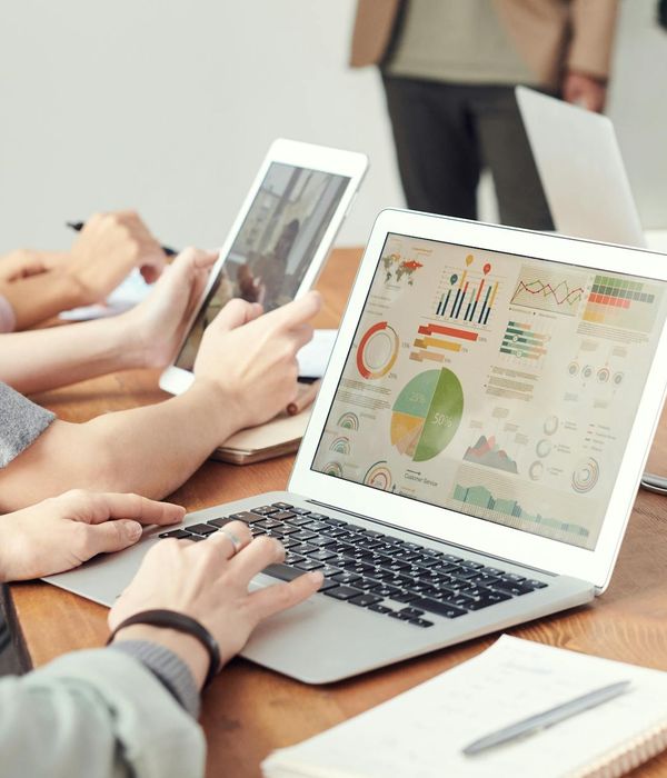 Business team analyzing HR data and metrics on computer screens